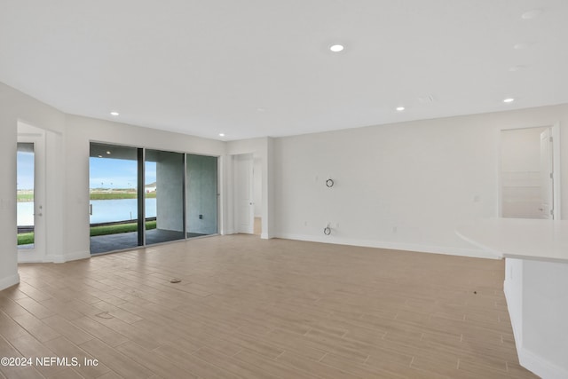 unfurnished room featuring a water view