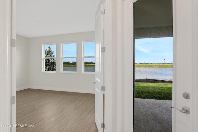 interior space with a water view and light hardwood / wood-style flooring