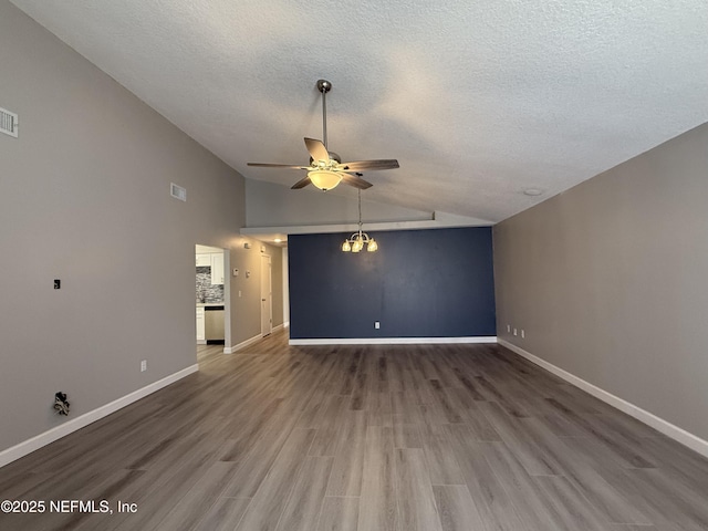 unfurnished living room featuring a textured ceiling, ceiling fan with notable chandelier, dark wood-type flooring, and lofted ceiling