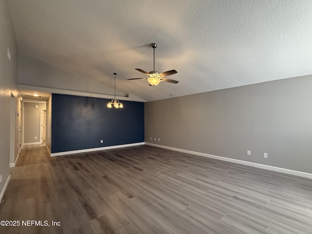 unfurnished living room with a textured ceiling, ceiling fan with notable chandelier, hardwood / wood-style flooring, and lofted ceiling