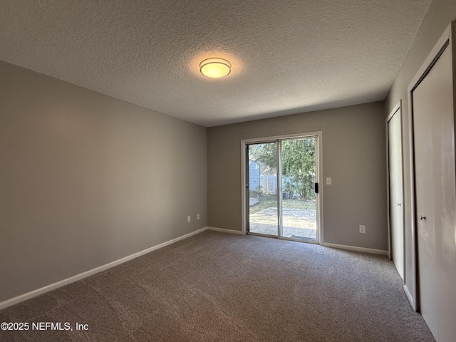 carpeted empty room featuring a textured ceiling