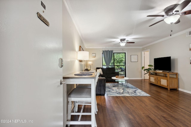 living room featuring ceiling fan, ornamental molding, and dark wood-type flooring