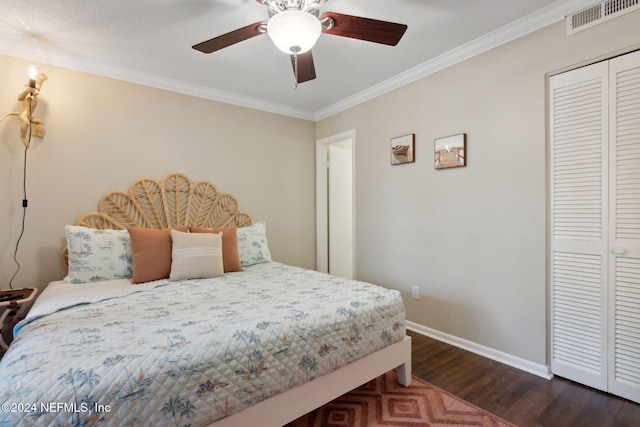 bedroom with ceiling fan, dark hardwood / wood-style flooring, crown molding, and a closet