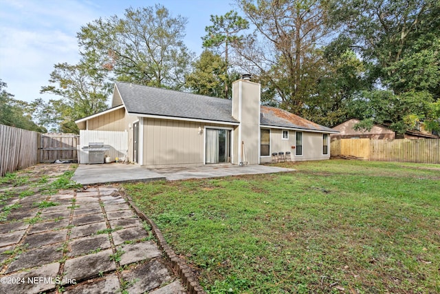 back of property with a lawn and a patio