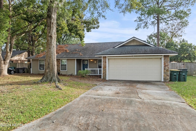 ranch-style house with covered porch, a front yard, and a garage