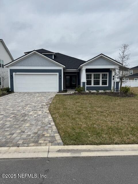 ranch-style home with a garage and a front lawn