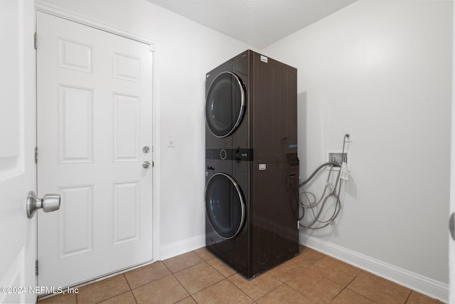 laundry room with stacked washer and clothes dryer and light tile patterned flooring