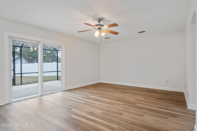 spare room featuring ceiling fan, a textured ceiling, and light hardwood / wood-style flooring