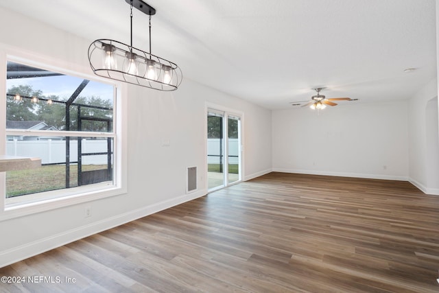 unfurnished dining area featuring hardwood / wood-style floors, ceiling fan, and a wealth of natural light