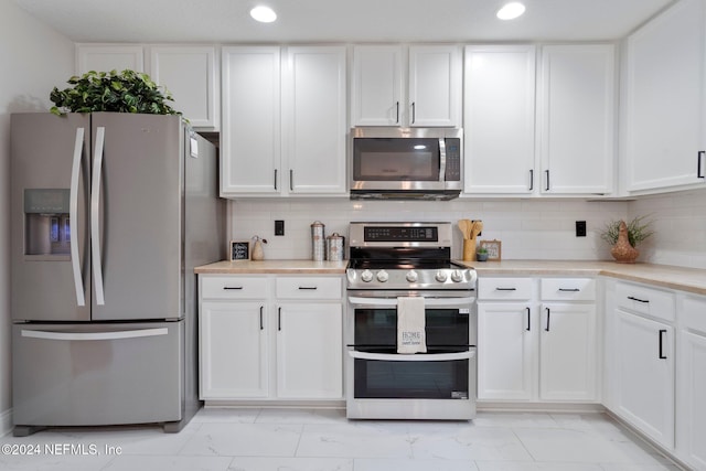 kitchen featuring appliances with stainless steel finishes, tasteful backsplash, and white cabinetry