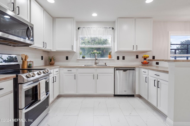 kitchen with white cabinets, appliances with stainless steel finishes, and sink