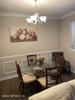 dining area featuring a chandelier, dark hardwood / wood-style flooring, and crown molding