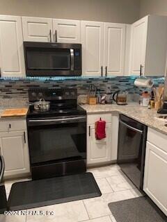 kitchen with black appliances, light tile patterned flooring, white cabinetry, and tasteful backsplash