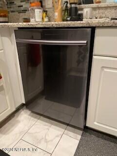 room details with light stone countertops and white cabinets