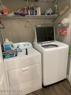 clothes washing area featuring washing machine and dryer and dark wood-type flooring