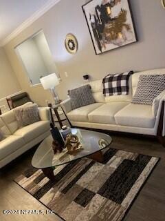 living room featuring dark hardwood / wood-style floors and ornamental molding