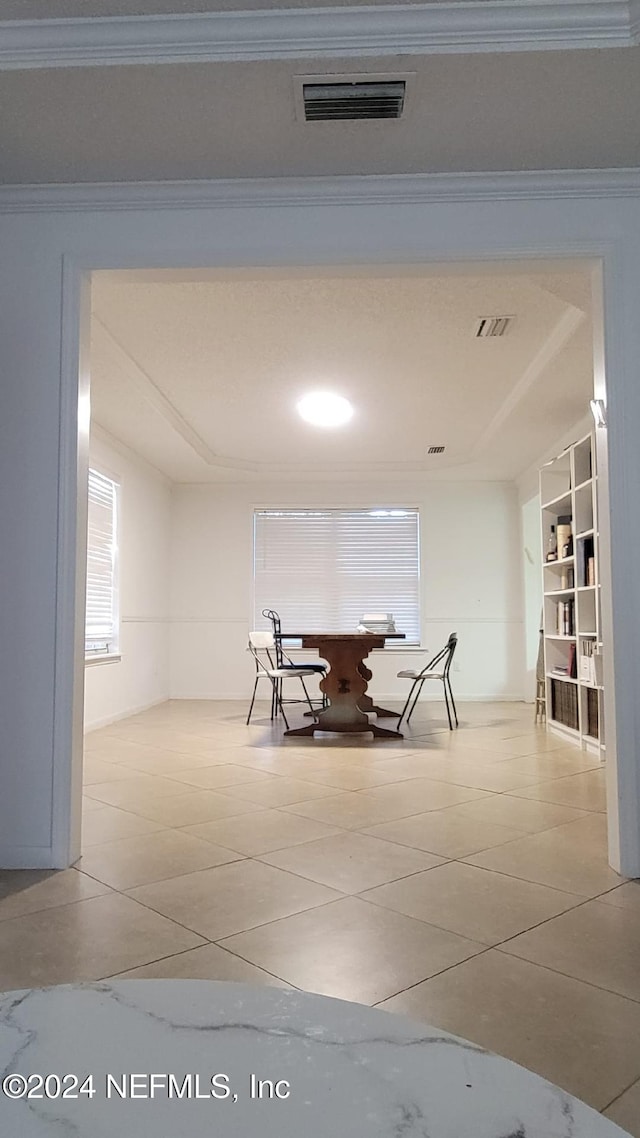 unfurnished dining area featuring built in shelves, light tile patterned floors, and crown molding