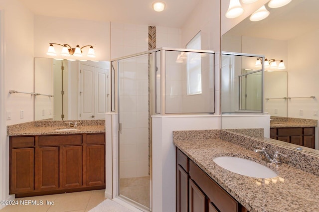 bathroom with tile patterned floors, a shower with door, and vanity