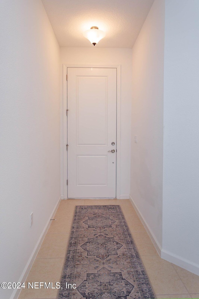 entryway featuring tile patterned flooring and a textured ceiling