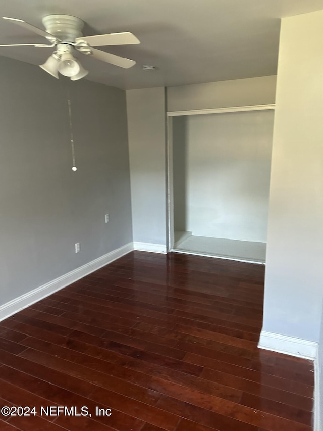 spare room with ceiling fan and dark wood-type flooring