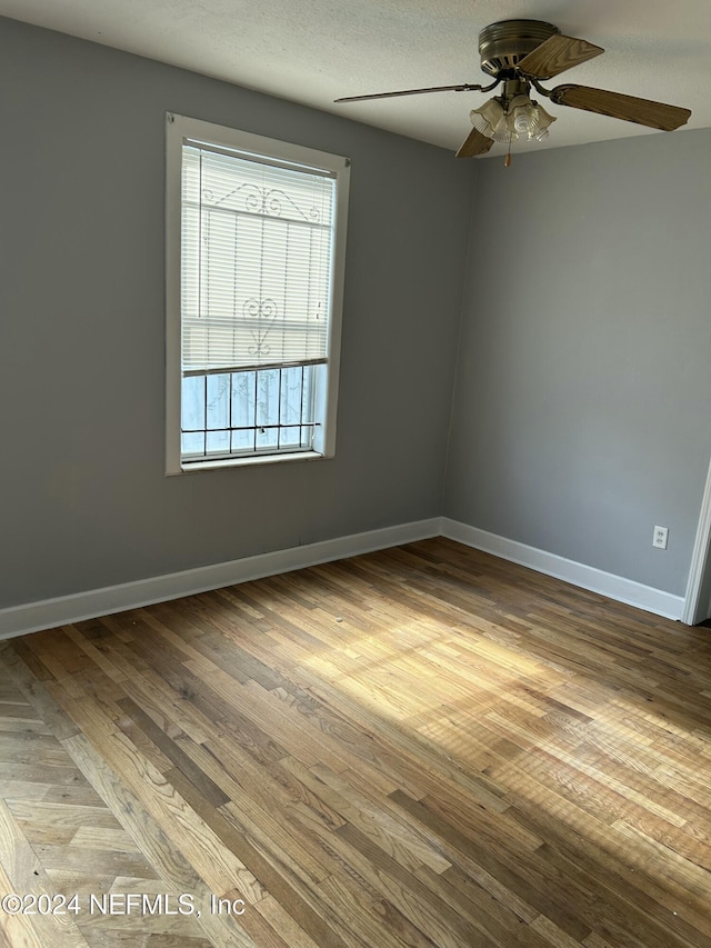 spare room featuring ceiling fan, light hardwood / wood-style floors, and a textured ceiling