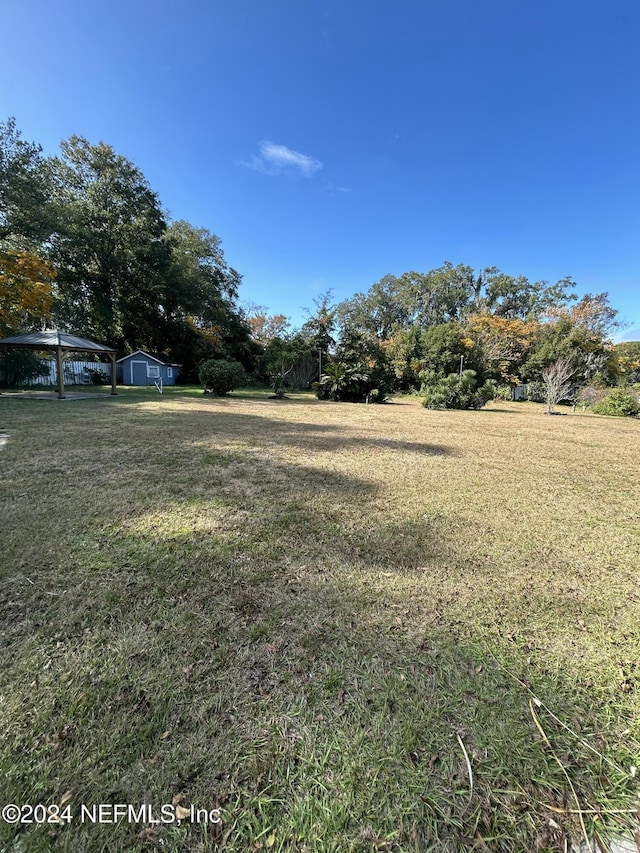 view of yard with a storage unit and a rural view