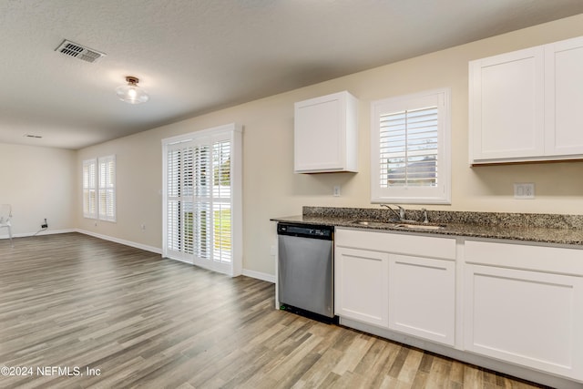 kitchen featuring sink, dark stone countertops, dishwasher, light hardwood / wood-style floors, and white cabinetry