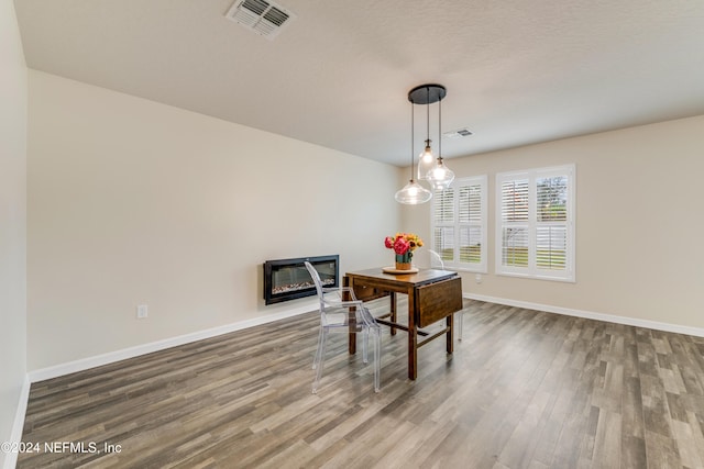 dining room with hardwood / wood-style floors and a textured ceiling