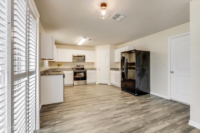 kitchen featuring white cabinets, light hardwood / wood-style floors, and appliances with stainless steel finishes