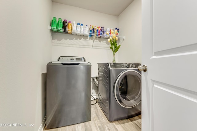 washroom featuring washing machine and clothes dryer and wood-type flooring