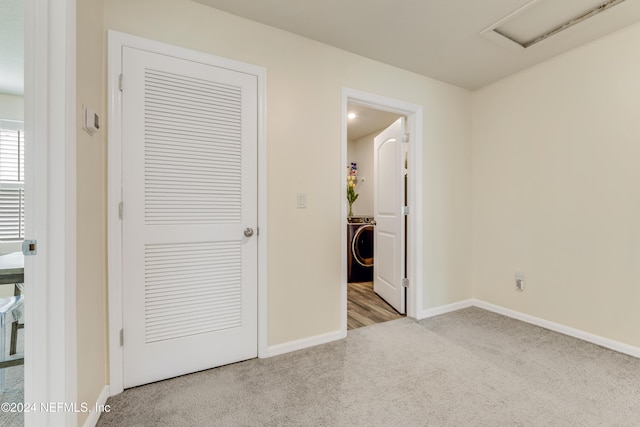 unfurnished bedroom featuring washer / dryer and light colored carpet