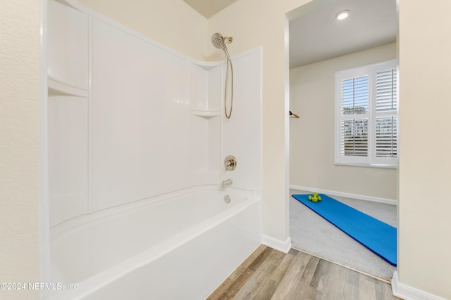 bathroom with hardwood / wood-style floors and shower / washtub combination