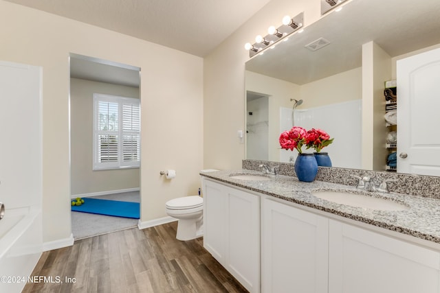 full bathroom with hardwood / wood-style floors, vanity, shower / bath combination, and toilet