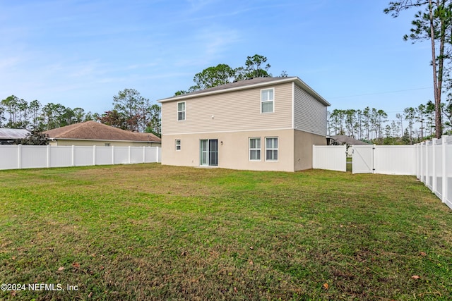 rear view of house featuring a lawn