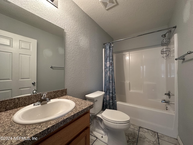 full bathroom featuring shower / bath combo with shower curtain, vanity, a textured ceiling, and toilet