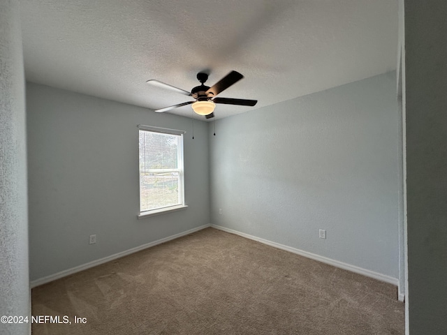 carpeted spare room with ceiling fan and a textured ceiling