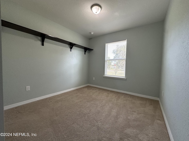 unfurnished room featuring carpet floors and a textured ceiling