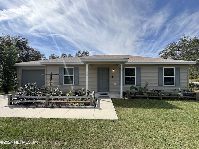 view of front of home with a front yard and a garage