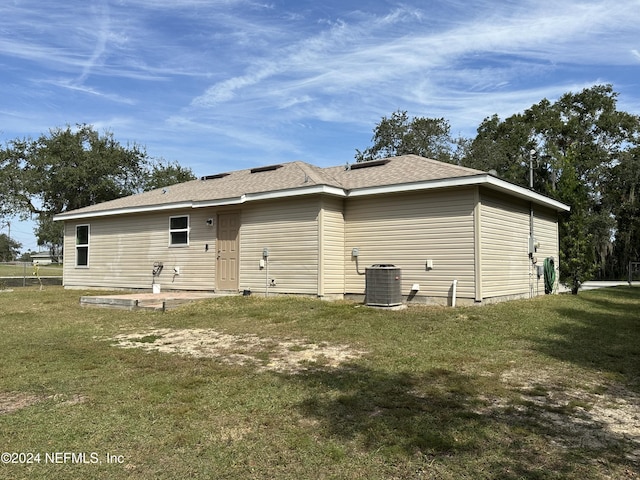 back of house featuring a lawn and central AC