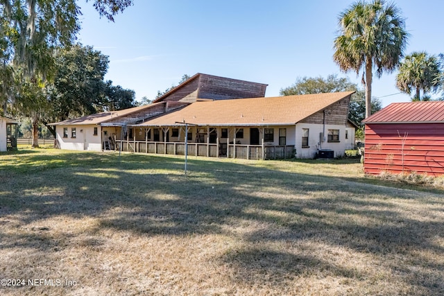 back of house featuring a yard and central AC unit