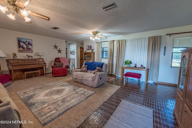 living room featuring ceiling fan and a textured ceiling