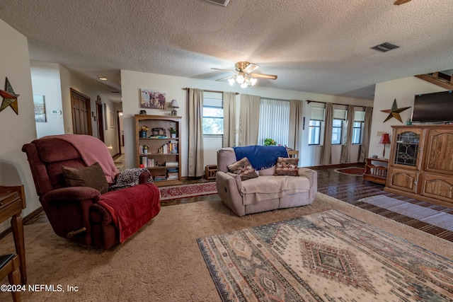 living room with carpet flooring, a textured ceiling, and ceiling fan