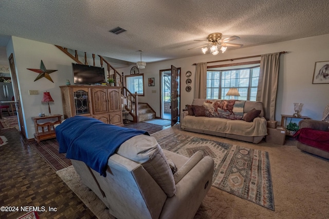 living room with dark colored carpet, a textured ceiling, and ceiling fan