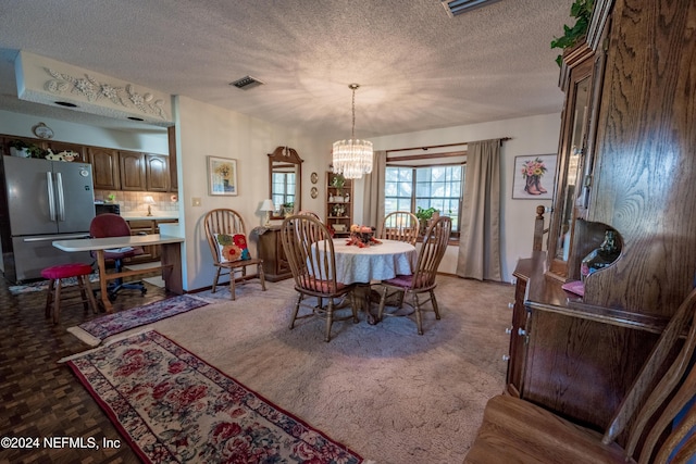 dining space featuring carpet flooring, a textured ceiling, and an inviting chandelier