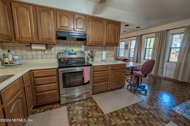 kitchen with dark parquet flooring, backsplash, kitchen peninsula, a textured ceiling, and electric stove