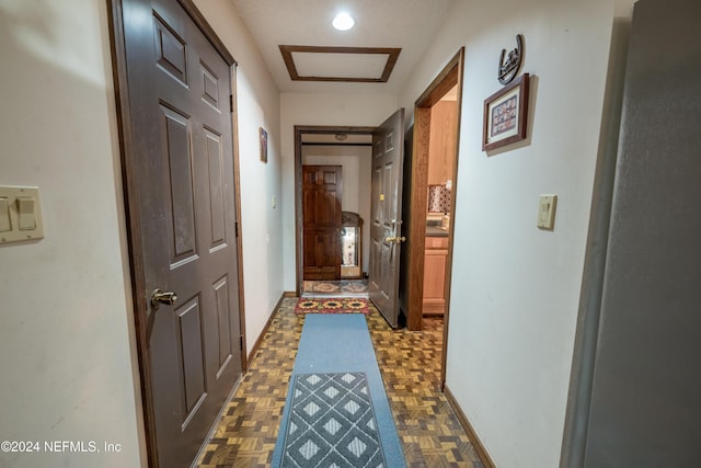 hall featuring dark parquet flooring and a textured ceiling