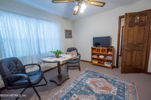 carpeted home office featuring ceiling fan