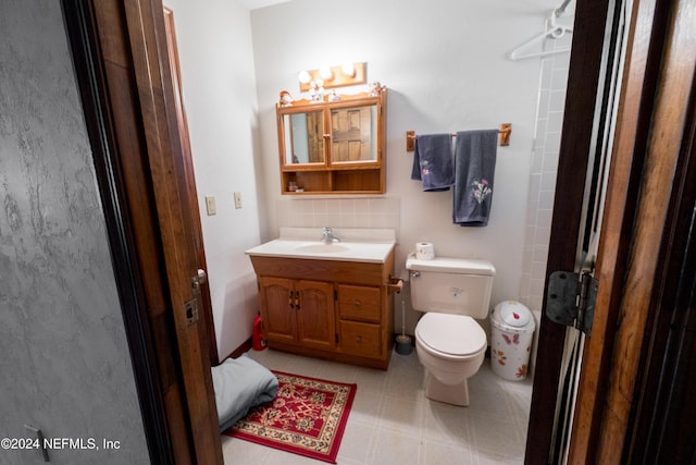 bathroom featuring vanity, tasteful backsplash, and toilet