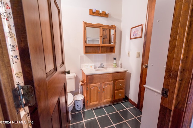 bathroom featuring decorative backsplash, vanity, and toilet