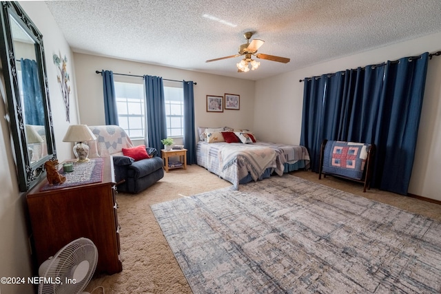 carpeted bedroom with a textured ceiling and ceiling fan